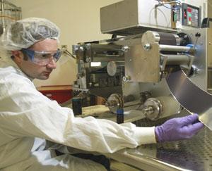 Matthew 
Robinson, solar engineer for Nanosolar in Palo Alto, examines a sheet of
 aluminum coated with semiconductor paint, a new product designed to 
dramatically reduce the cost of manufacturing a solar cell.